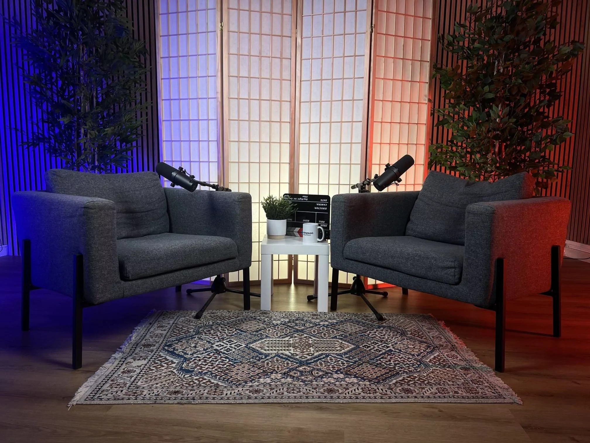 Plateau face-à-face Underground Production avec deux fauteuils et micros, éclairage bicolore